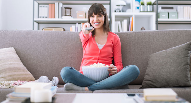 woman relaxing on the couch at home and watching videos online 