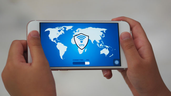 User holding mobile phone with an application connecting to a secure network via VPN
